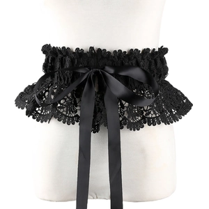 Close-up of black floral lace corset belt with a glossy satin ribbon bow detail