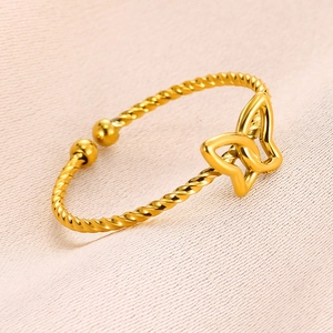 Detail of a gold-plated twisted cable bracelet featuring a hollow butterfly charm
