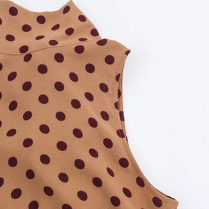 Detail of high collar and brown polka dot print texture on the sleeveless midi dress