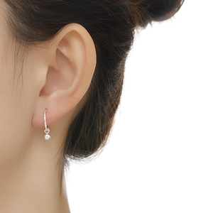 Close-up of minimalist S999 silver hoop earrings with a small bead pendant on model