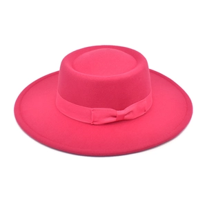 Detail of wool felt boater hat featuring a bright pink ribbon and delicate bow accent