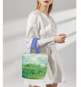 Detail of Van Gogh oil painting printed tote bag with blue handles held by a model