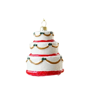 Three-tier glittery Christmas cake ornament with red and gold details on white background