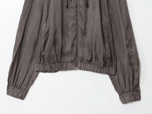 Detail of charcoal grey bomber jacket showing elastic hem, cuffs and metallic zipper