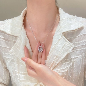 Detail shot of heart-shaped projection necklace with micro-paved crystals on a model