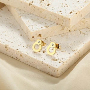 Detailed close-up of gold-plated handcuff earrings with sparkling cubic zirconia accents