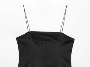 Détail d'une robe en satin noir avec de fines bretelles et une texture de tissu lisse