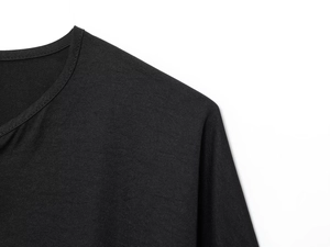 Detailed close-up of the black knitted fabric neck and shoulder seam on a casual shirt