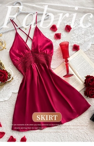 Detail of red silk slip dress featuring deep V-neckline and intricate floral lace trim