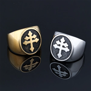Macro shot of gold and silver stainless steel rings with black Cross of Lorraine relief