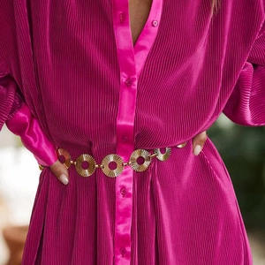 Magenta pleated long sleeve V-neck top styled with a gold geometric sunburst chain belt