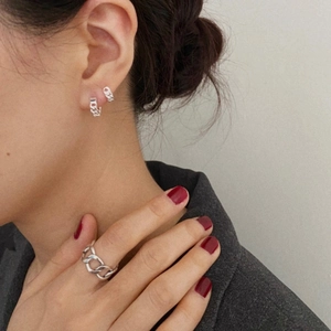 Close-up of a 925 sterling silver chain earrings and ring set worn by a model