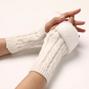 Detailed close-up of white cable knit fingerless gloves with soft faux fur cuffs