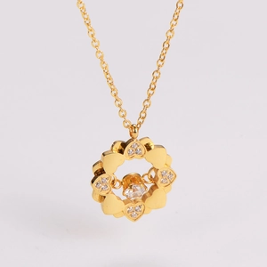 Detail of clover heart pendant necklace with shimmering zircon stone in gold finish