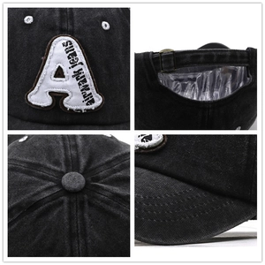Detail view of washed denim baseball cap with letter embroidery and metal buckle closure