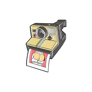 Retro camera metal pin with creative geometric photo detail on white background