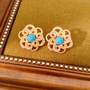 Detail of vintage hollow flower earrings with blue turquoise and sparkling rhinestones