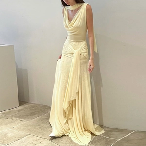 Detail of a backless mesh long dress in cream featuring a cowl neck and waist knot