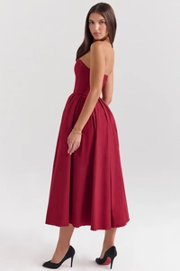 Detailed side view of deep red corset midi dress showing pleated skirt texture and a-line shape
