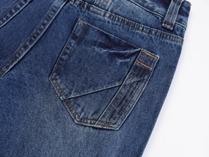 Detail of dark blue vintage jeans featuring orange stitching and folded pocket design