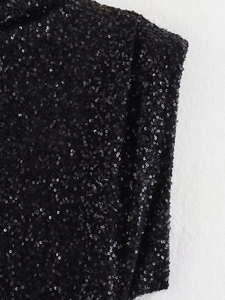 Close-up of sparkling black sequins on an elegant slim-fit evening dress