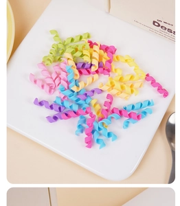 Nahaufnahme von pastellfarbenen Spirallockenbändern auf einem weißen Tablett für Mädchen