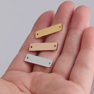 Detail of 6x22mm rectangular stainless steel charms in gold, rose gold, and silver finishes