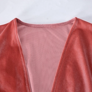 Détails macro du tissu en velours rose corail et coutures fines sur l'encolure