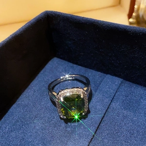 Macro shot of an oval emerald ring with diamond halo in a velvet jewelry box