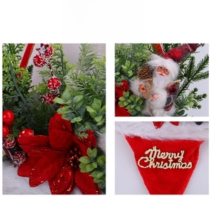 Detail of Christmas wreath with Santa doll, pine needles, red berries and gold Merry Christmas sign