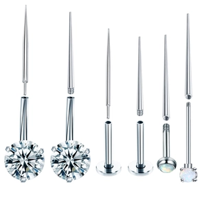 Detailed view of surgical steel piercing studs with opal, zircon, and internal threads