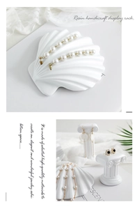 Detailed view of white shell and Roman column resin jewelry display stands for necklaces