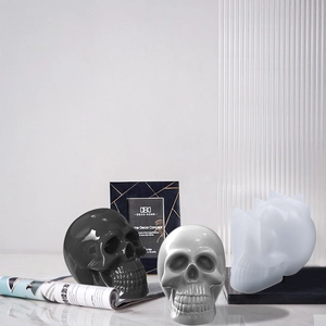 Dettaglio dello stampo in silicone a teschio con creazioni finite in resina nera e grigia