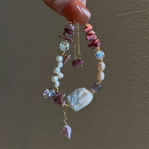 Close-up of Baroque pearl bracelet with pink rose quartz and gold chain detail