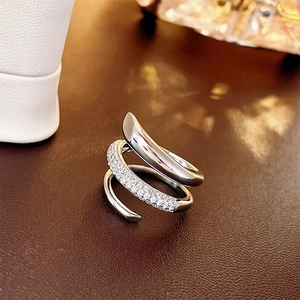 Macro shot of silver triple-layered spiral ring with pavé-set zircon on leather surface