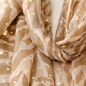 Macro detail of zebra print cotton linen scarf with golden dots and textured soft fabric