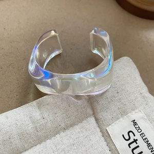 Close-up of iridescent acrylic cuff bracelet with transparent blue-purple glow