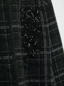 Detail of dark grey plaid knit fabric with black sequin and bead floral embroidery