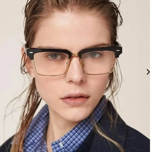 Modern black and gold square half-frame sunglasses worn by a model on a beige background