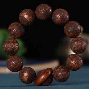 Détail macro de perles en bois de santal de 20mm avec gravures d'écritures bouddhistes