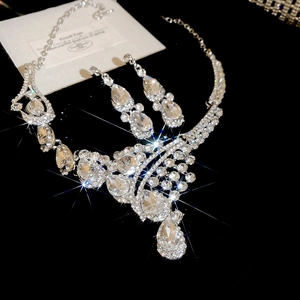 Detailed view of silver water drop necklace and earrings set with zircons on velvet