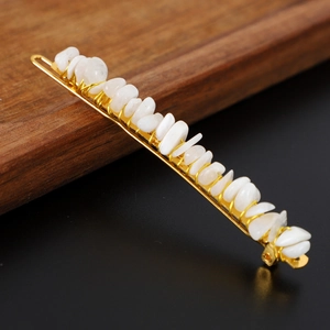 Detailed macro view of white natural stone fragments on a gold metal hairpin