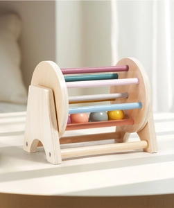Detail of Montessori wooden rotating drum toy with colorful rods and internal rolling balls