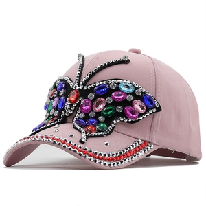 Pink women's baseball cap featuring a large colorful rhinestone butterfly embellishment
