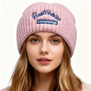 Close-up of pink chunky knit beanie featuring blue Bestchoice dog themed embroidery