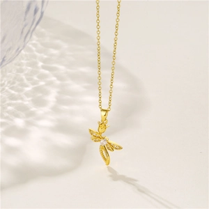 Elegant gold stainless steel dragonfly necklace with zircon wings on beige background