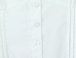 Close-up of white cotton fabric texture with three transparent round buttons on the shirt