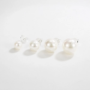 Set of four S925 sterling silver pearl stud earrings in varying sizes on white background