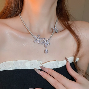 Detail of silver floral necklace with zircon petal charms and a teardrop pendant