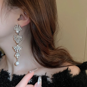 Elegant silver tassel earrings with sparkling rhinestones and pearls on a female model